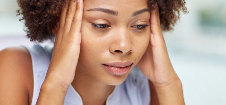 people, emotions, stress and health care concept - unhappy african american young woman touching her head and suffering from headache